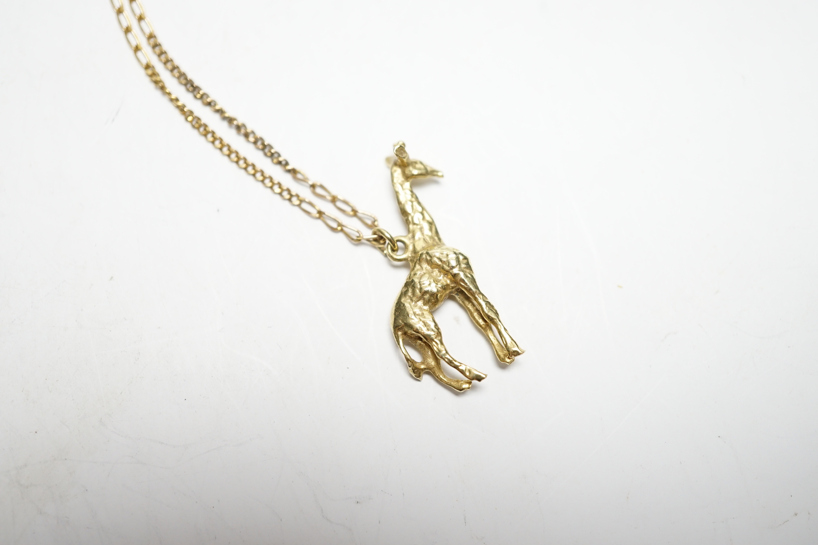 A South African yellow metal giraffe pendant, 30mm, on a 9k chain, gross weight 7.4 grams.